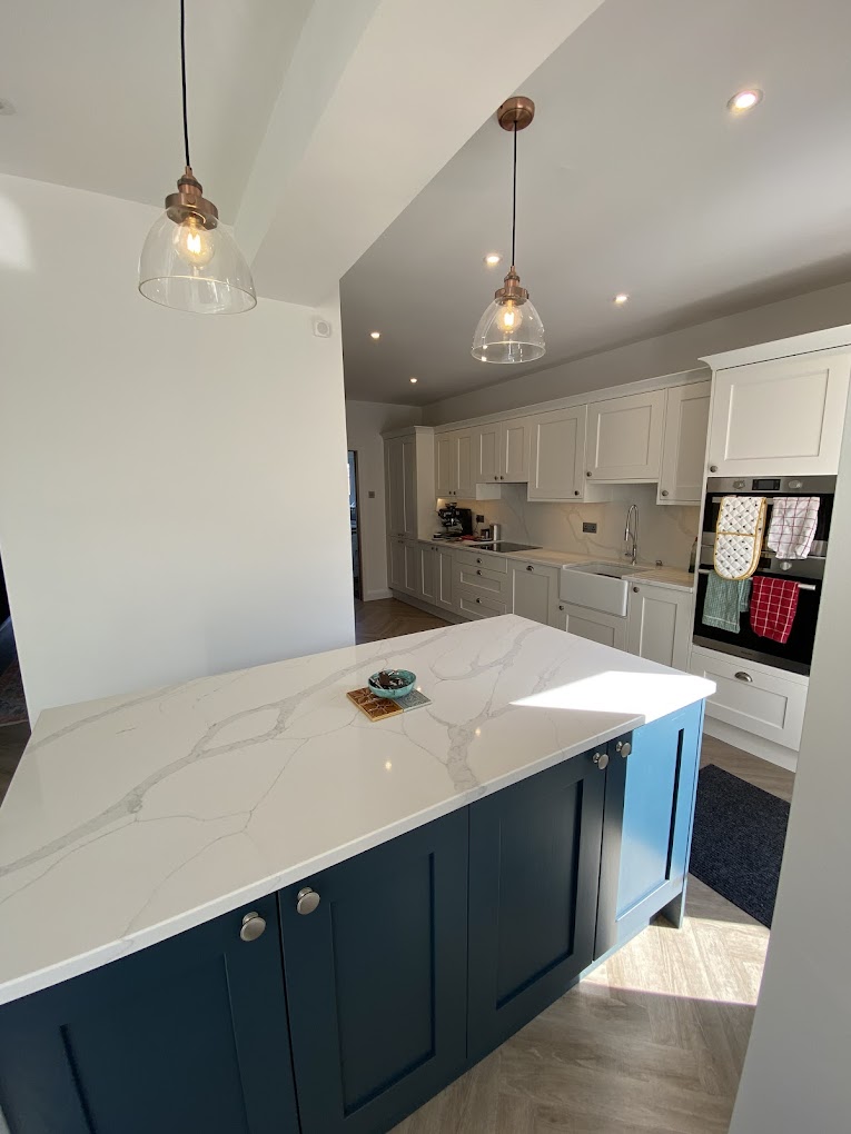 Kitchen island with copper pendant lights and downlights