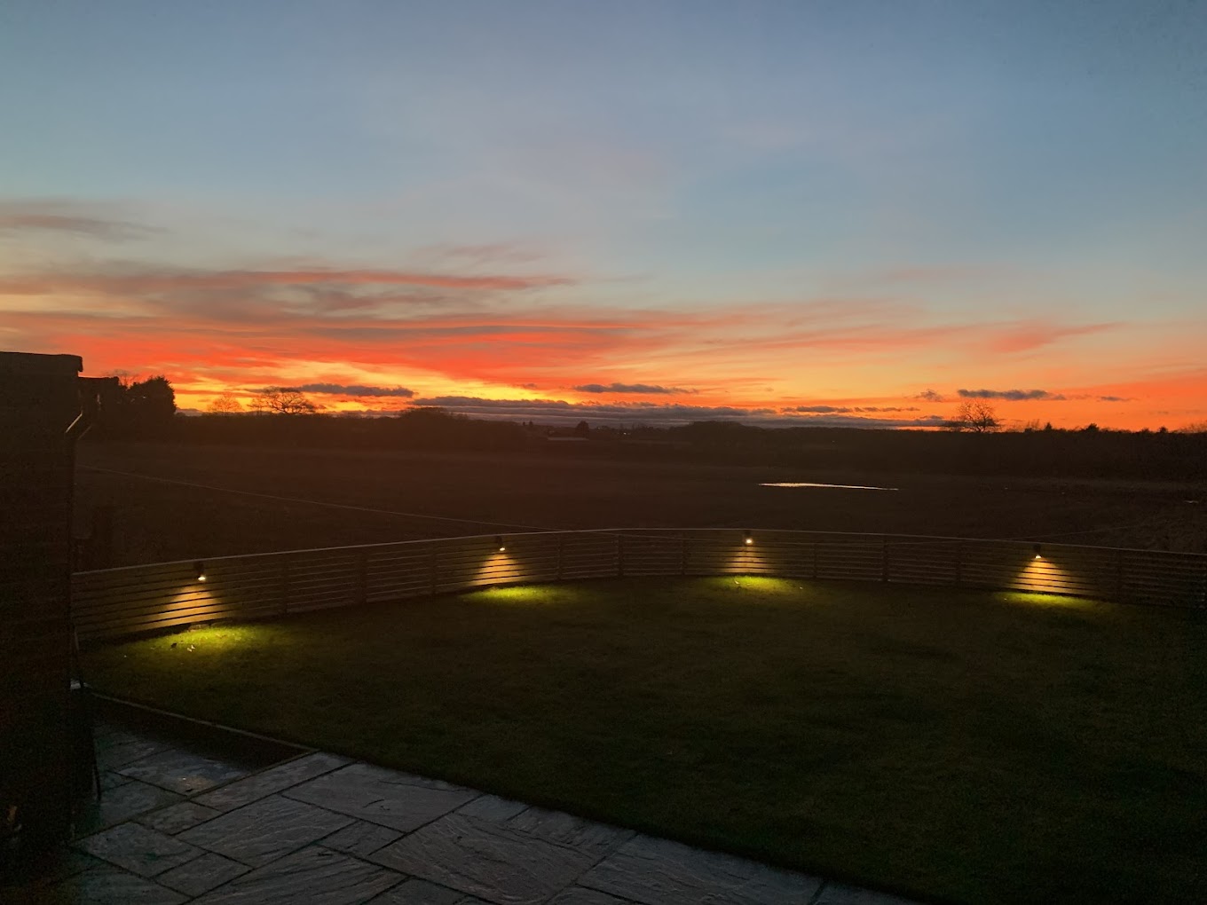 Garden fence downlighters at sunset